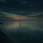 Great Salt Lake shoreline at dusk with faint shadowy figures over the water