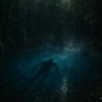 Shadowy humanoid figure moving beneath the surface of the Blue Hole spring in Ohio representing the Blue Hole Monster legend