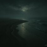 A sandbar exposed at low tide with a calm ocean and misty atmosphere