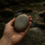 A smooth stone from a river being held for healing